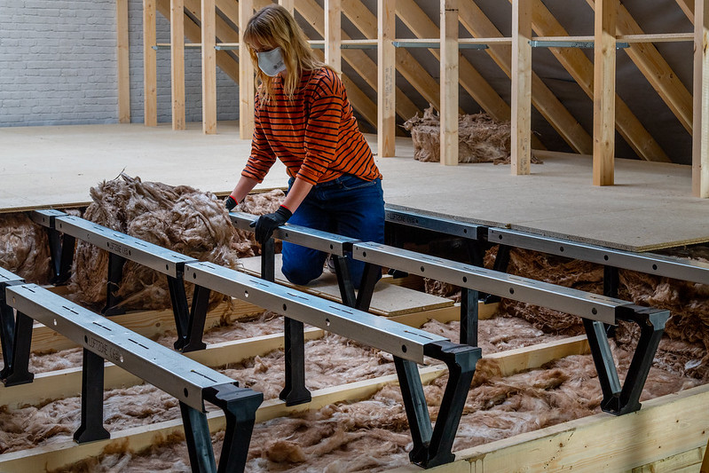 women installing underfloor insulation